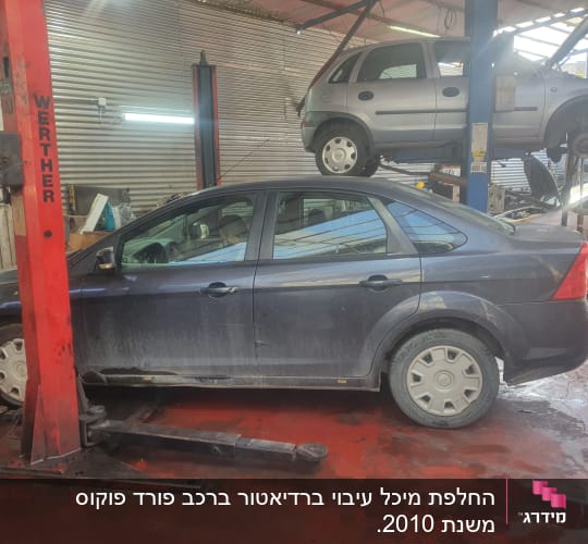 שני רכבים במוסך על מעליות הרמה